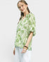 Woman wearing a green floral blouse against a white background