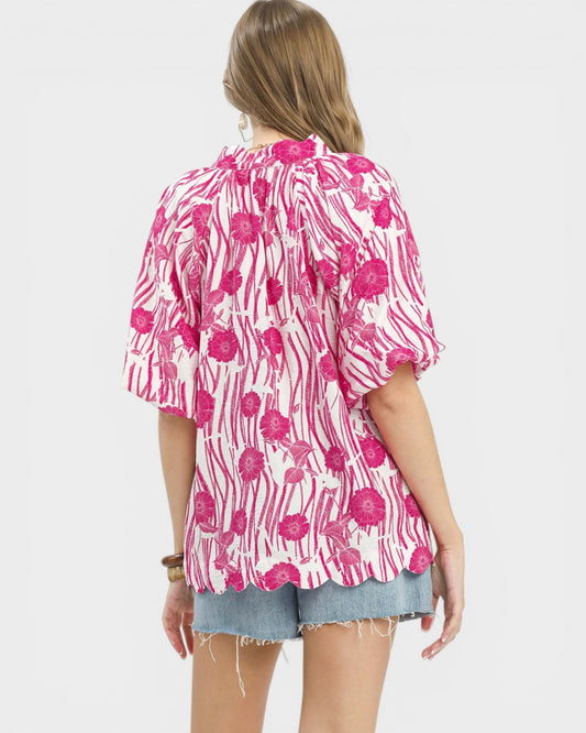 Woman wearing a pink floral kimono-style top on a white background