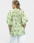Woman wearing a green patterned blouse on a white background