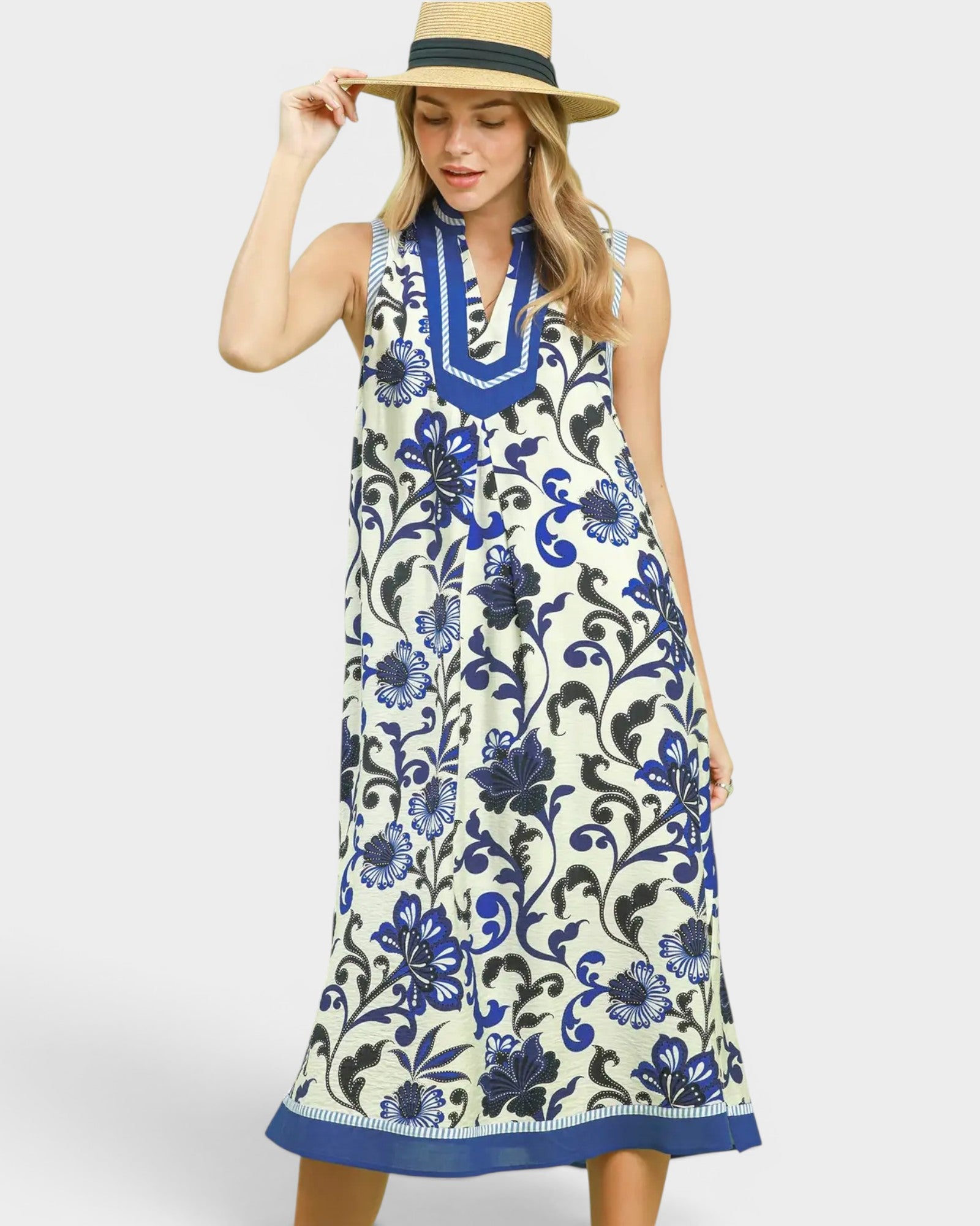 Woman wearing a sleeveless dress with blue floral pattern on a white background