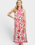 Woman wearing a floral dress with pink accents on a white background