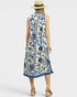 Woman wearing a sleeveless floral dress with blue patterns on a white background