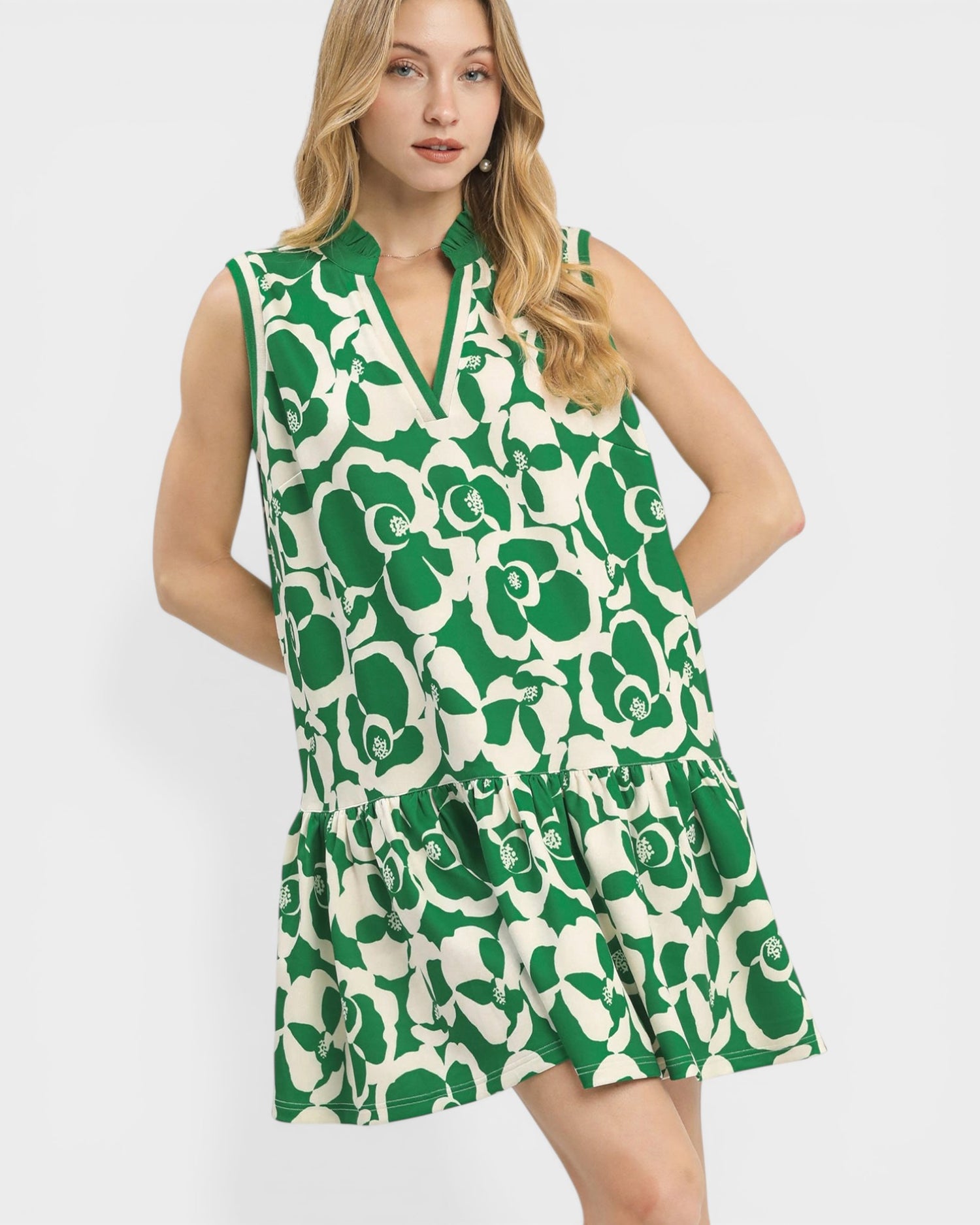Woman wearing a green and white floral dress on a white background