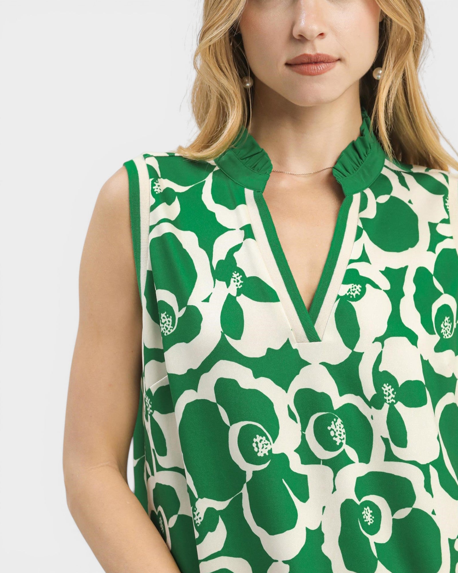 Woman wearing a green and white floral patterned dress on a white background