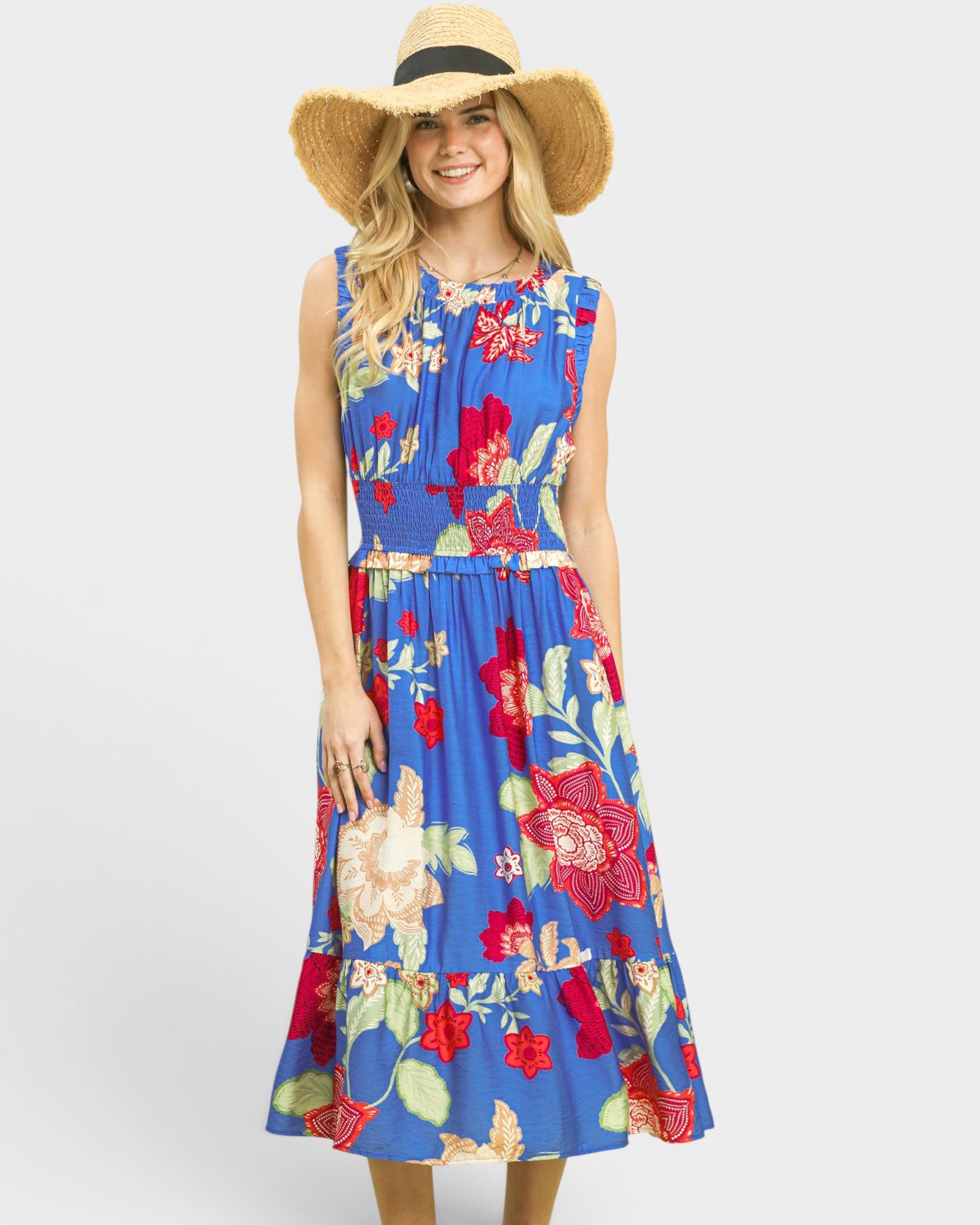 Woman wearing a blue floral dress with a wide-brimmed hat on a white background