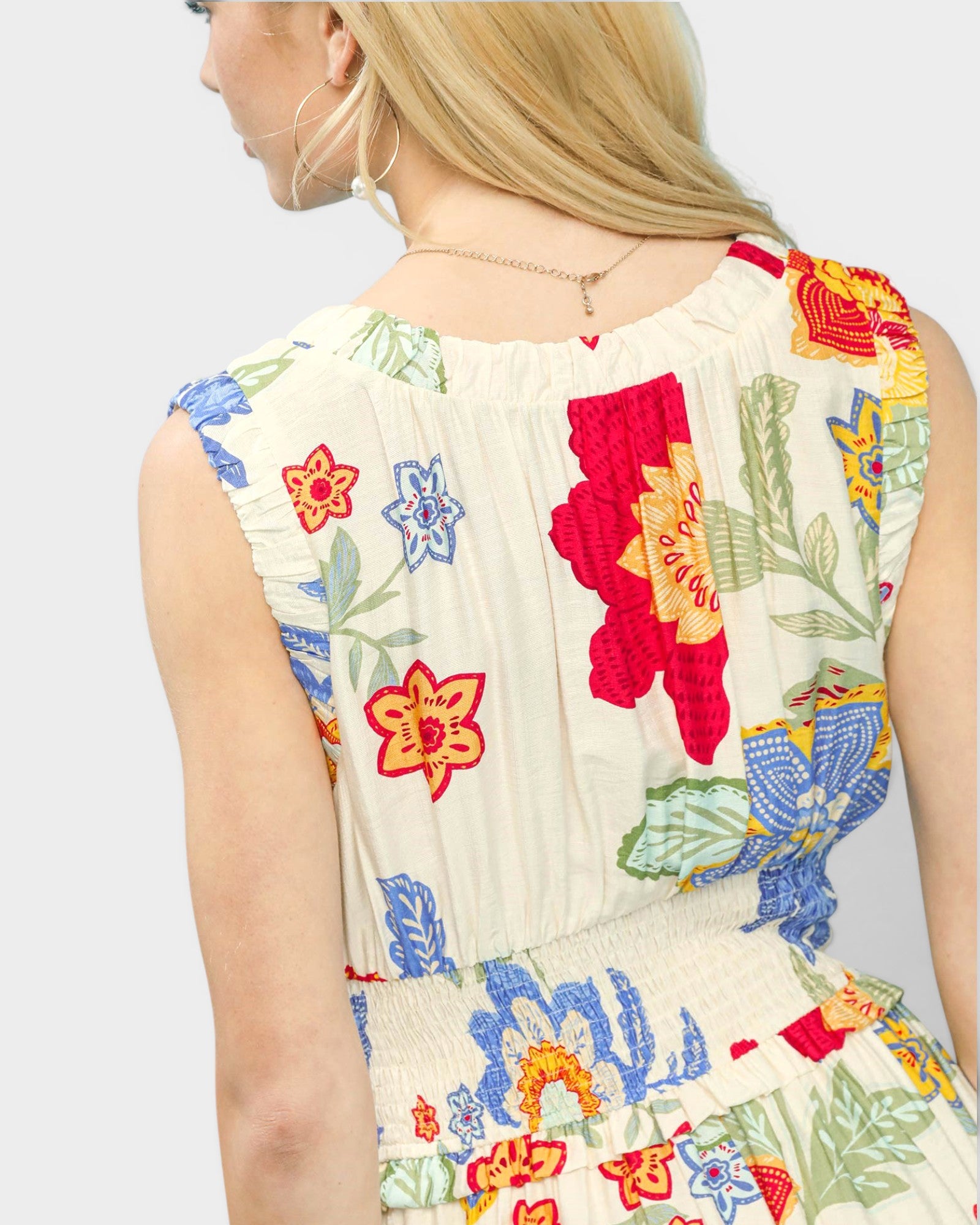Colorful floral pattern on a sleeveless top against a plain background