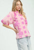 Woman wearing a pink floral blouse with light blue jeans on a white background