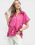 Woman wearing a pink blouse with floral patterns on a white background