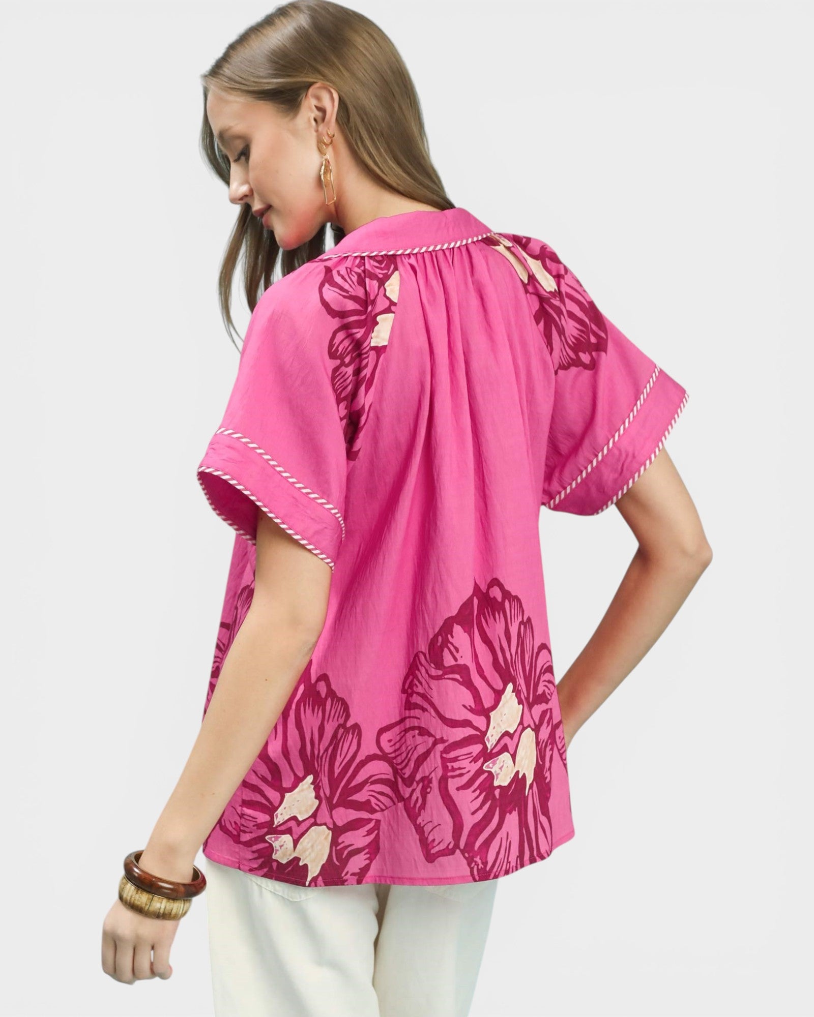 Woman wearing a pink floral blouse on a light gray background