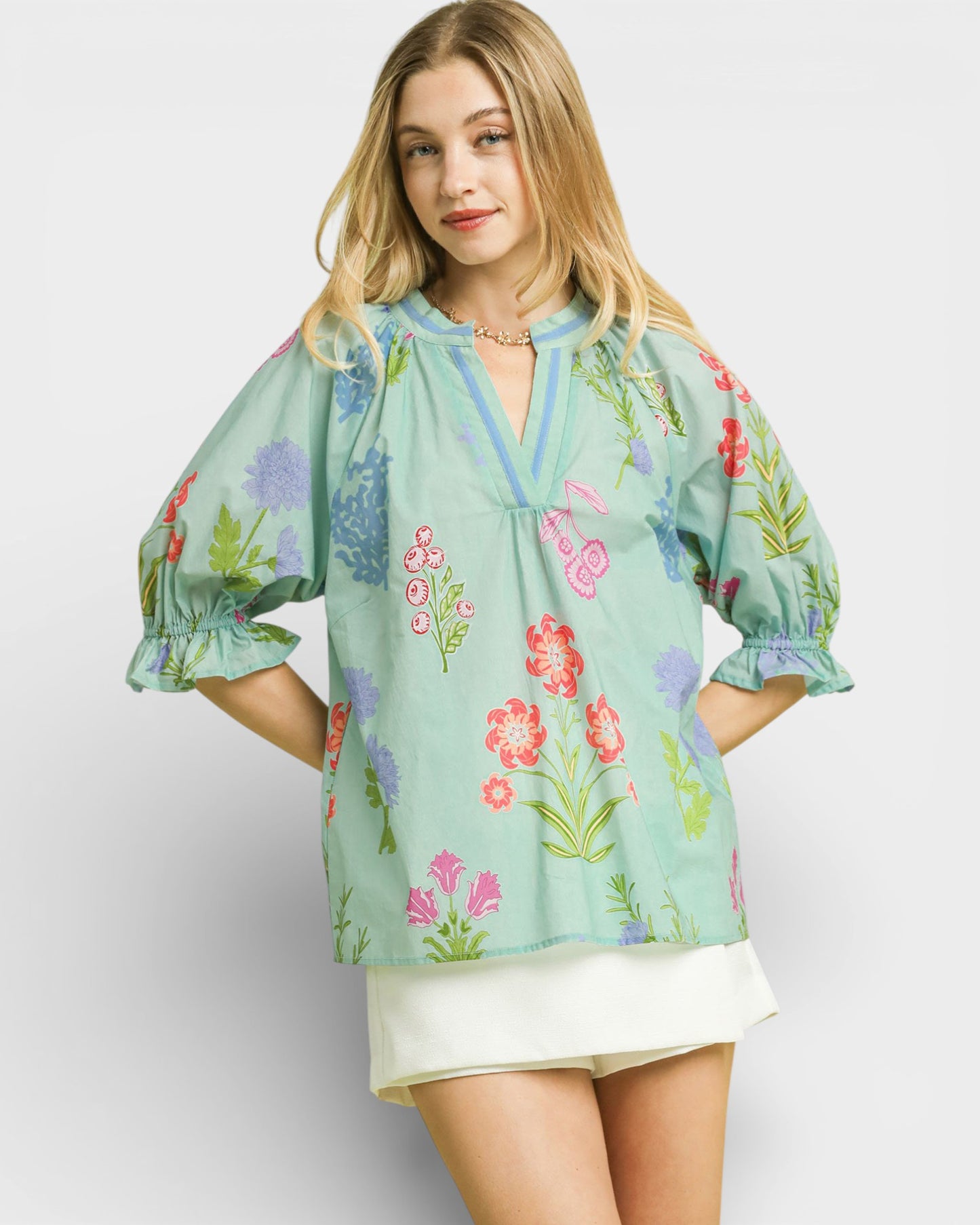 Woman wearing a light blue floral blouse on a white background