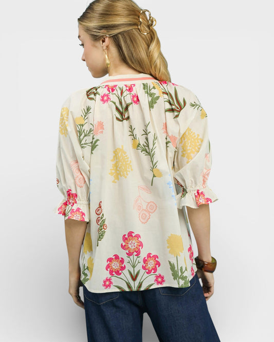 Woman wearing a floral blouse with a plain background