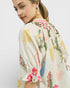 Woman wearing a floral kimono-style garment on a plain background