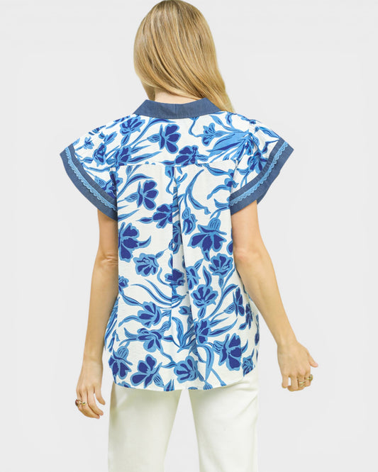 Woman wearing a blue floral patterned top on a white background