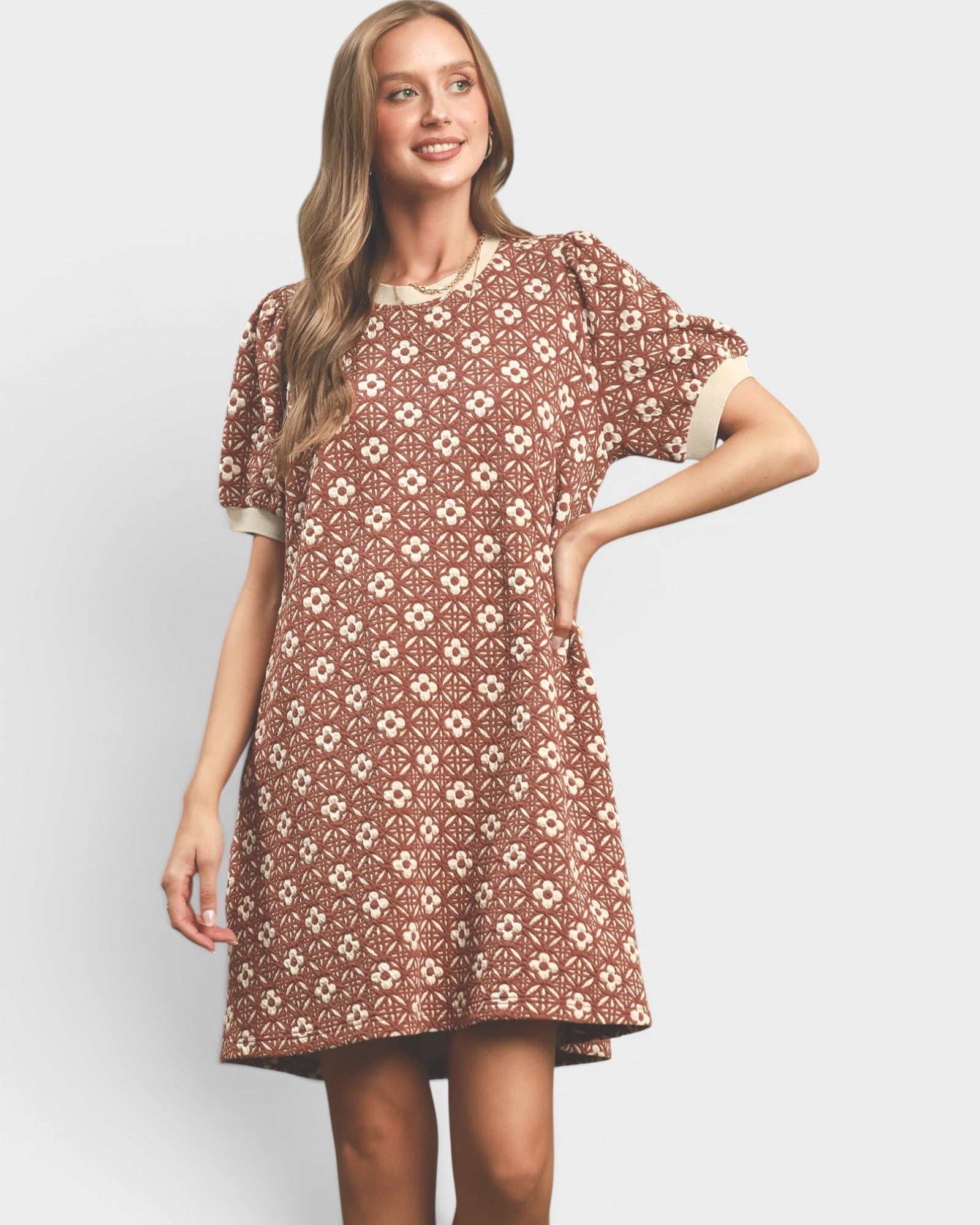 Woman wearing a patterned dress on a plain background