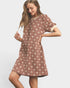 Woman wearing a patterned dress on a plain background