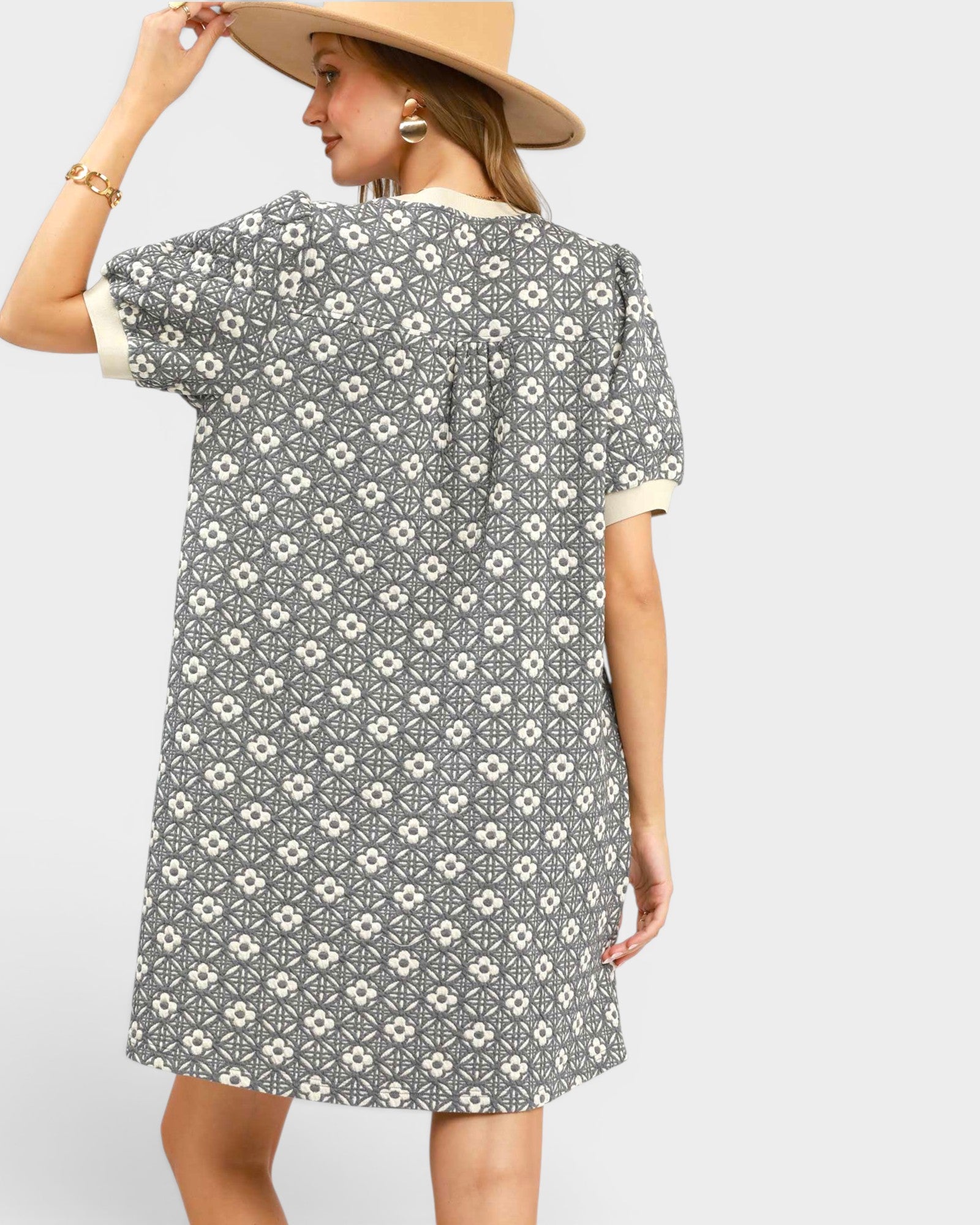 Woman wearing a patterned dress with a plain background