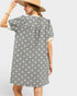Woman wearing a patterned dress with a plain background