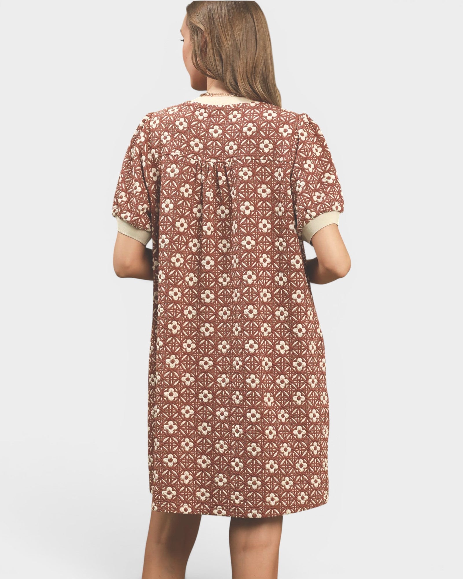 Woman wearing a patterned dress on a white background