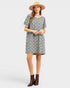 Woman wearing a patterned dress and brown boots on a white background