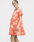 Woman wearing a coral floral dress on a white background