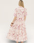 Woman wearing a floral dress on a plain background