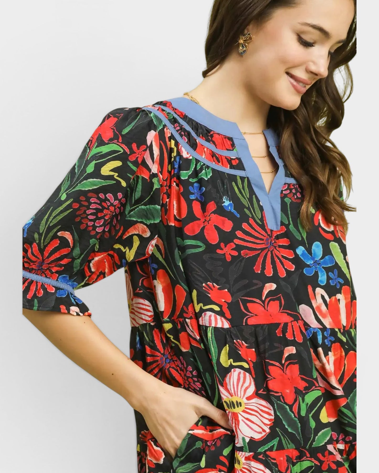 Woman wearing a colorful floral dress with a plain background