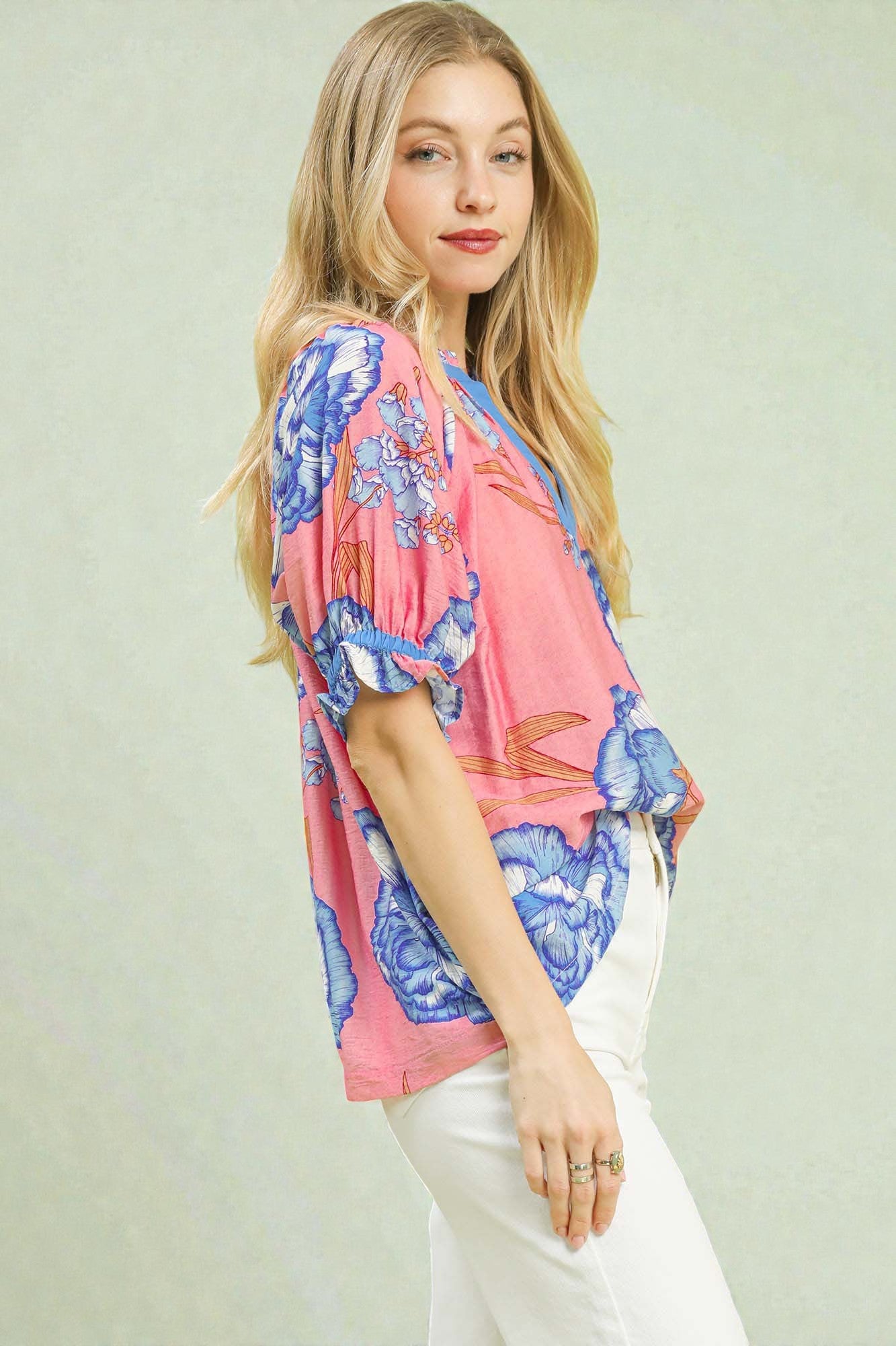 Woman wearing a colorful floral kimono-style top against a light green background