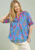 Woman wearing a blue floral blouse with a plain background