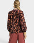 Person wearing a floral blouse and pants on a white background