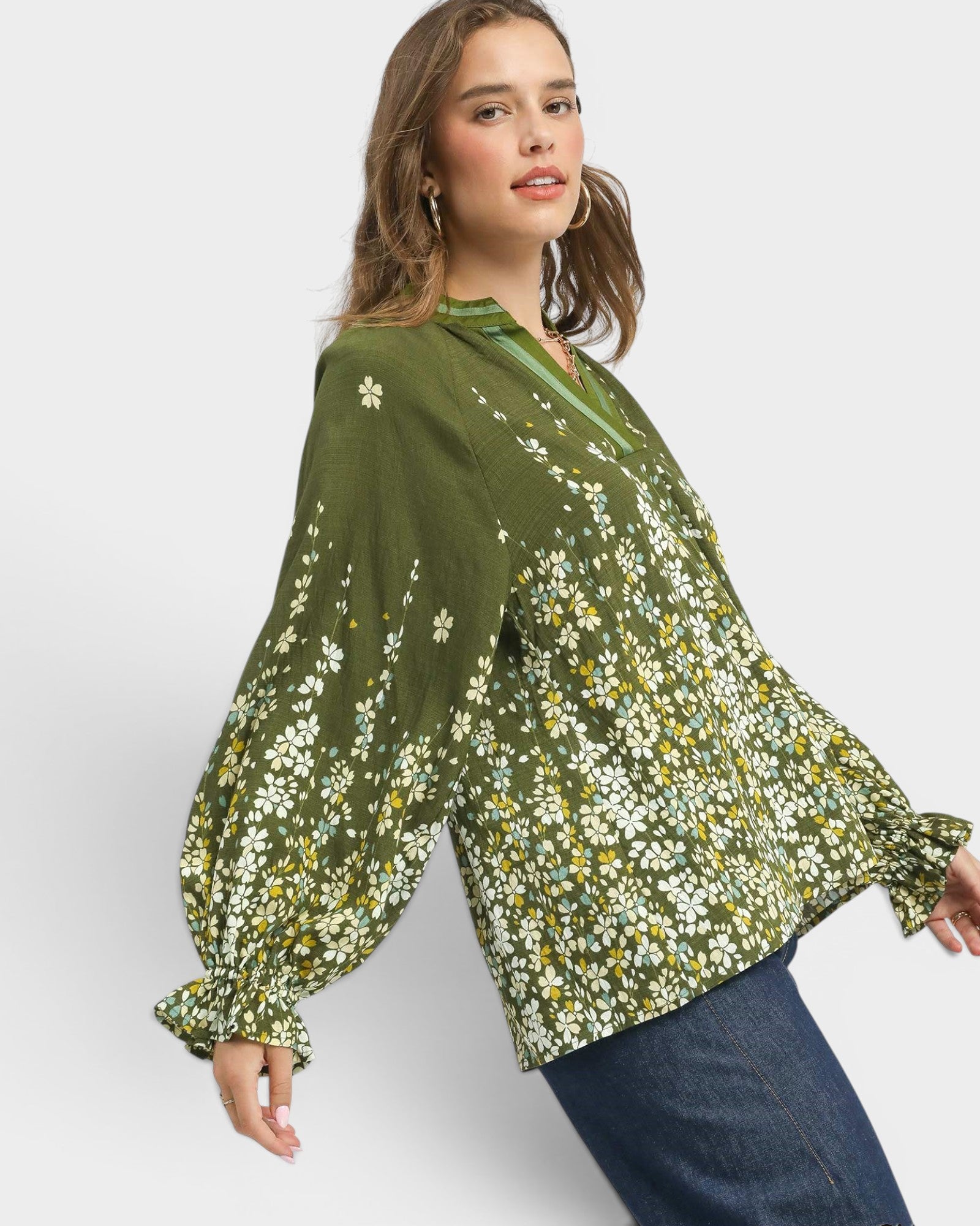 Woman wearing a green floral blouse against a white background