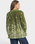 Woman wearing a green floral blouse with a plain background