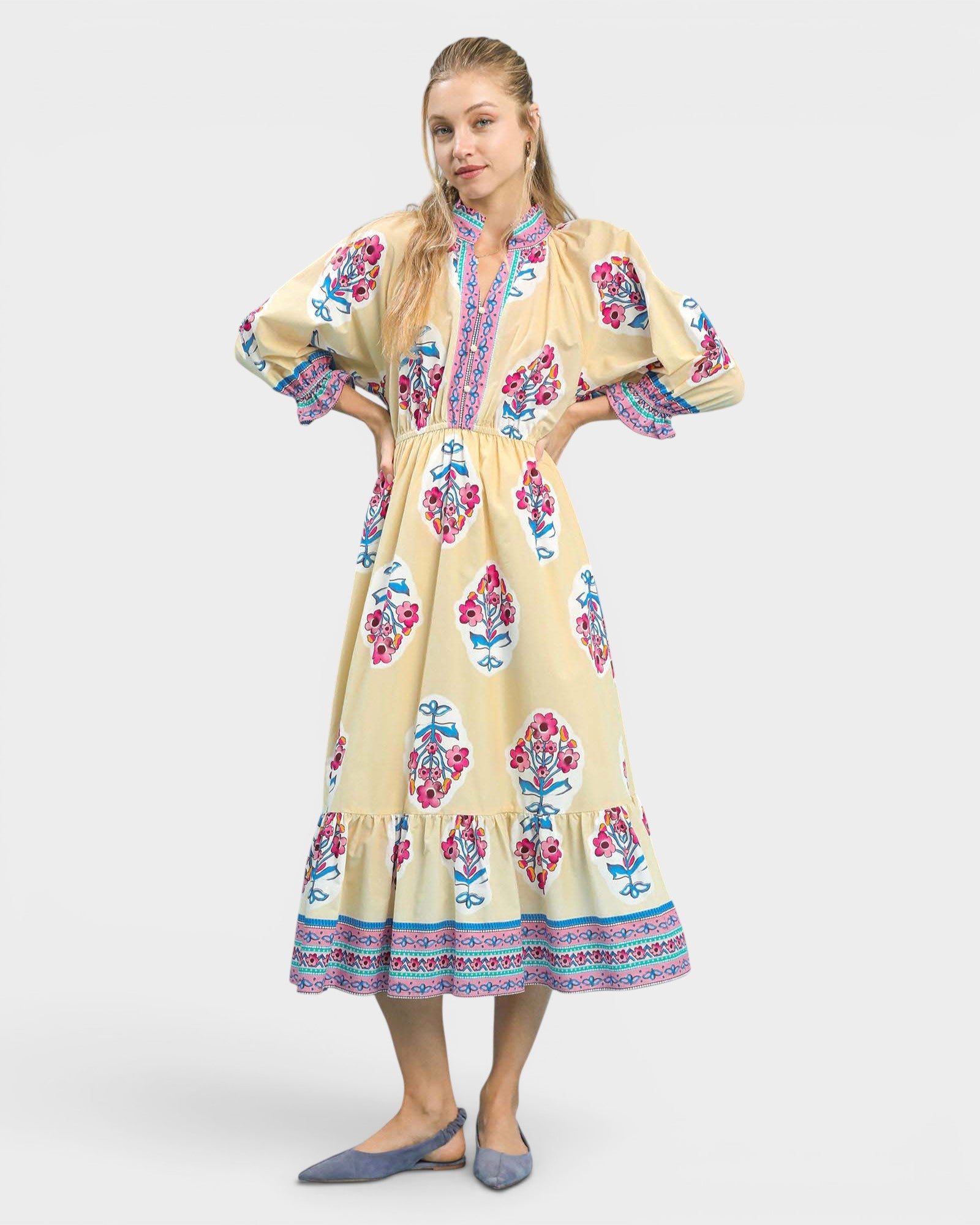 Woman wearing a yellow dress with floral patterns on a white background