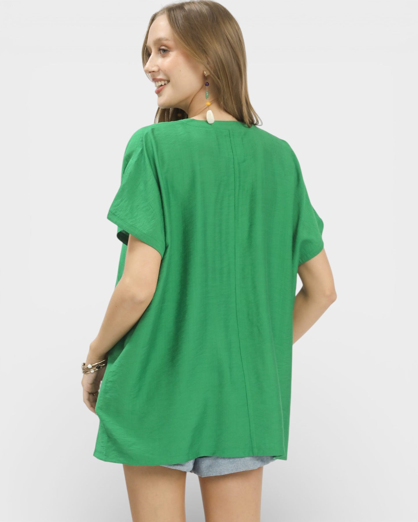 Woman wearing a green oversized shirt on a white background