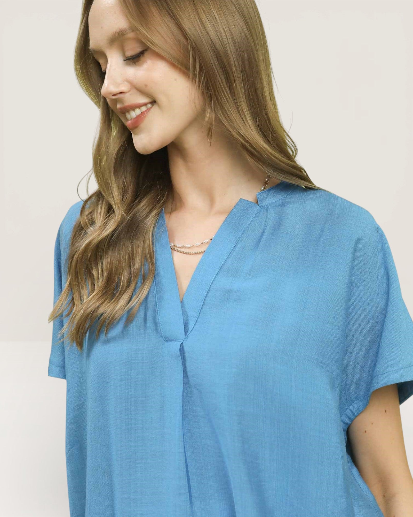 Woman wearing a blue top against a plain background