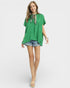 Woman wearing a green blouse and denim shorts on a white background