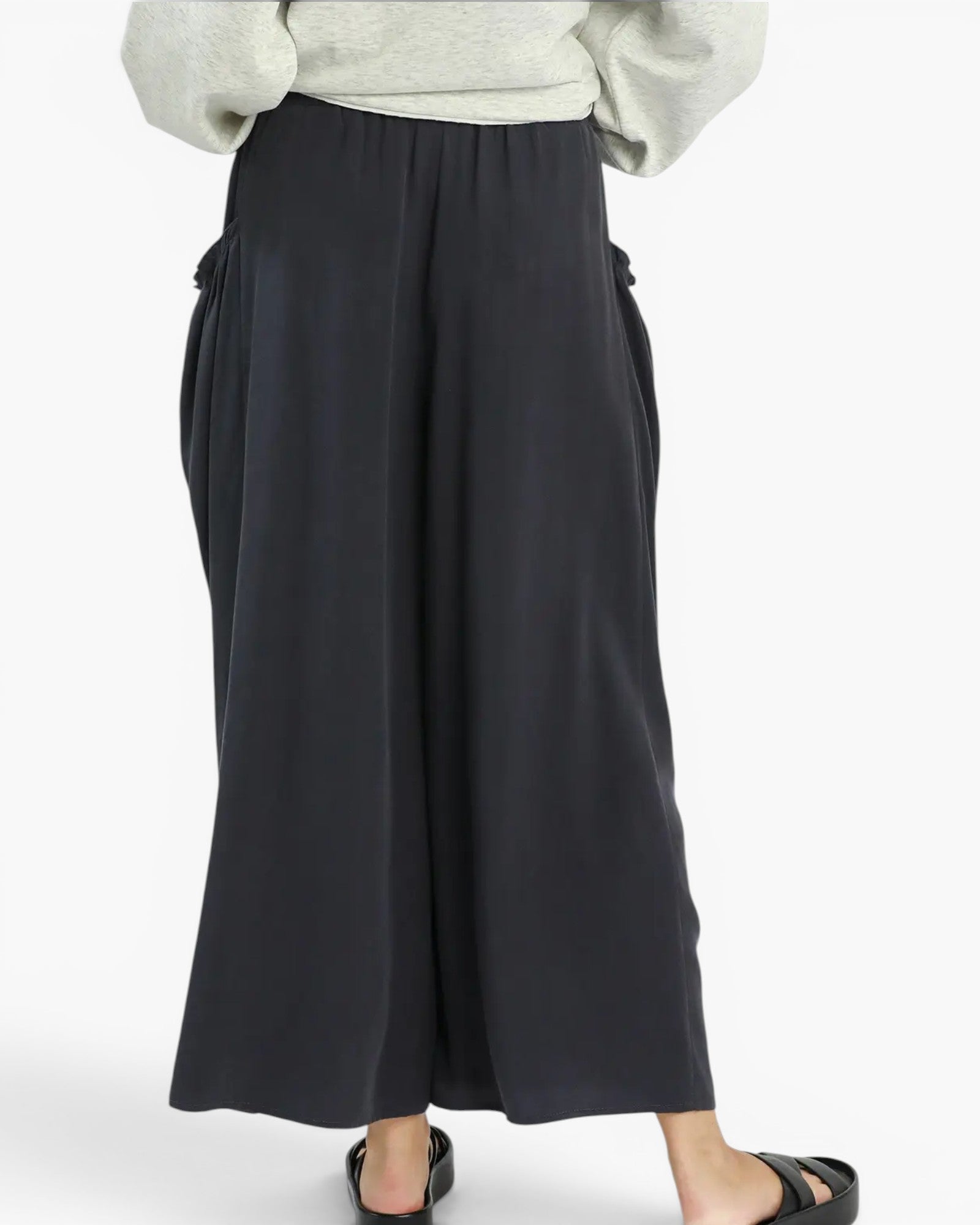 Black wide-leg cropped pants with side tie details, shown on a model wearing a light gray top and black sandals against a plain white background.