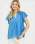 Woman wearing a blue blouse with ruffled sleeves on a white background
