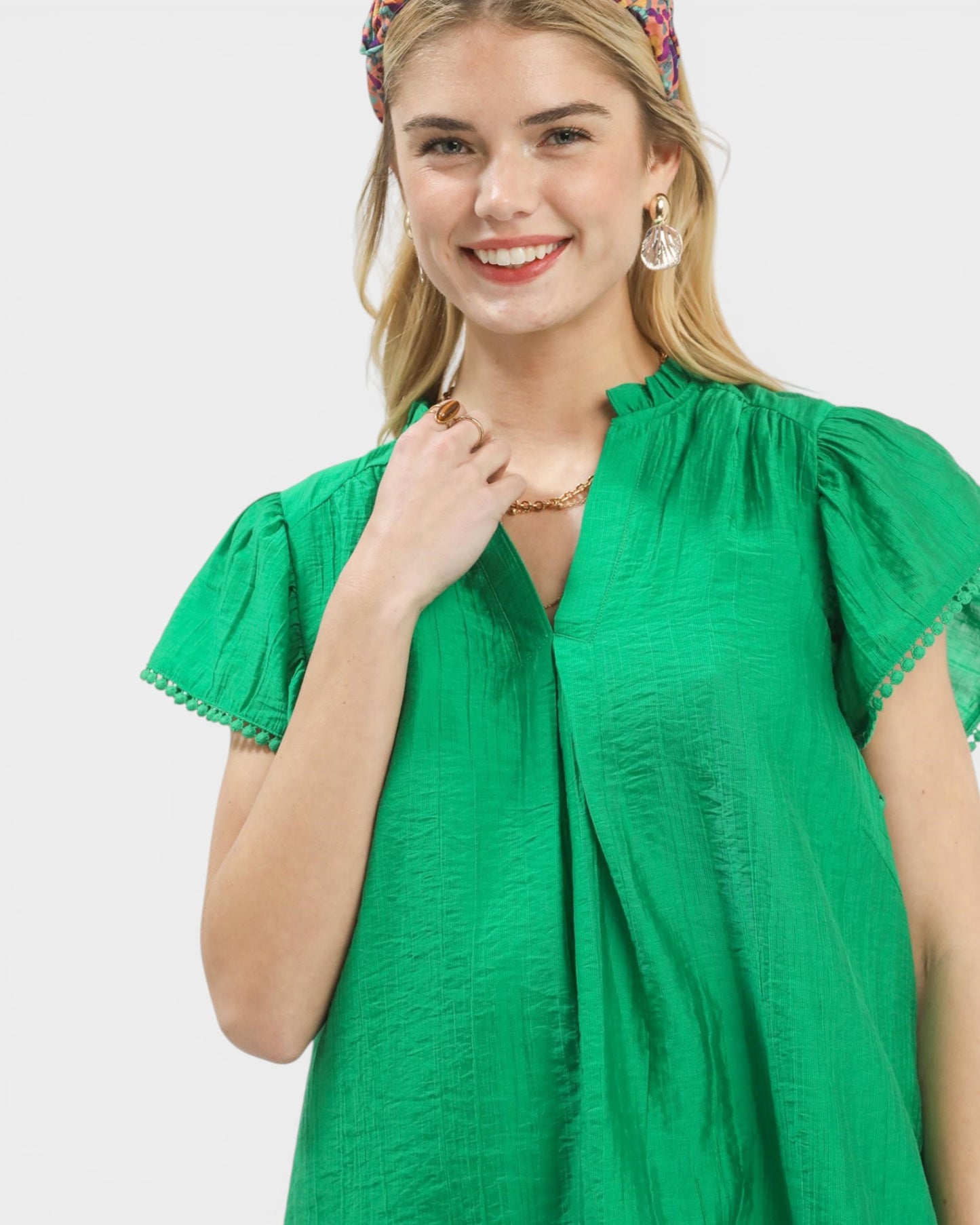 Woman wearing a green dress with puffed sleeves on a white background