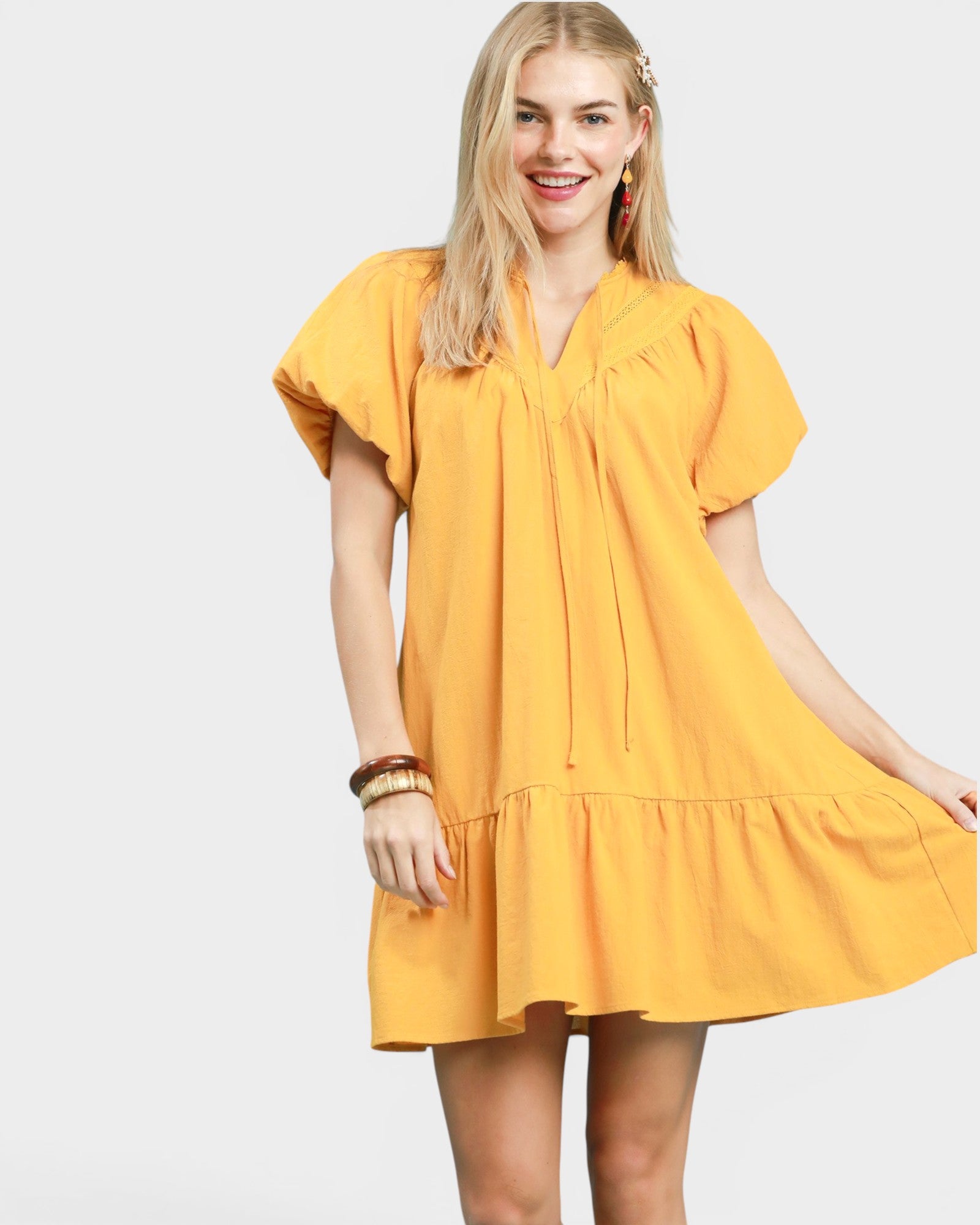 Woman wearing a yellow dress on a white background