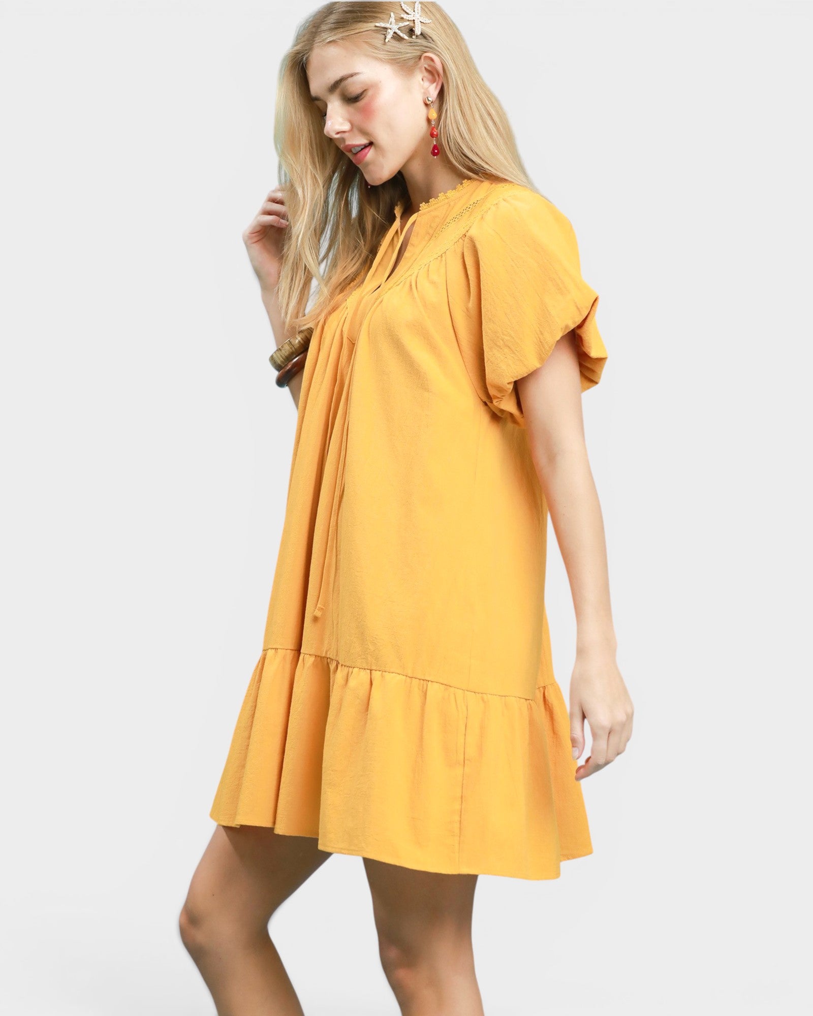 Woman wearing a mustard yellow dress on a white background