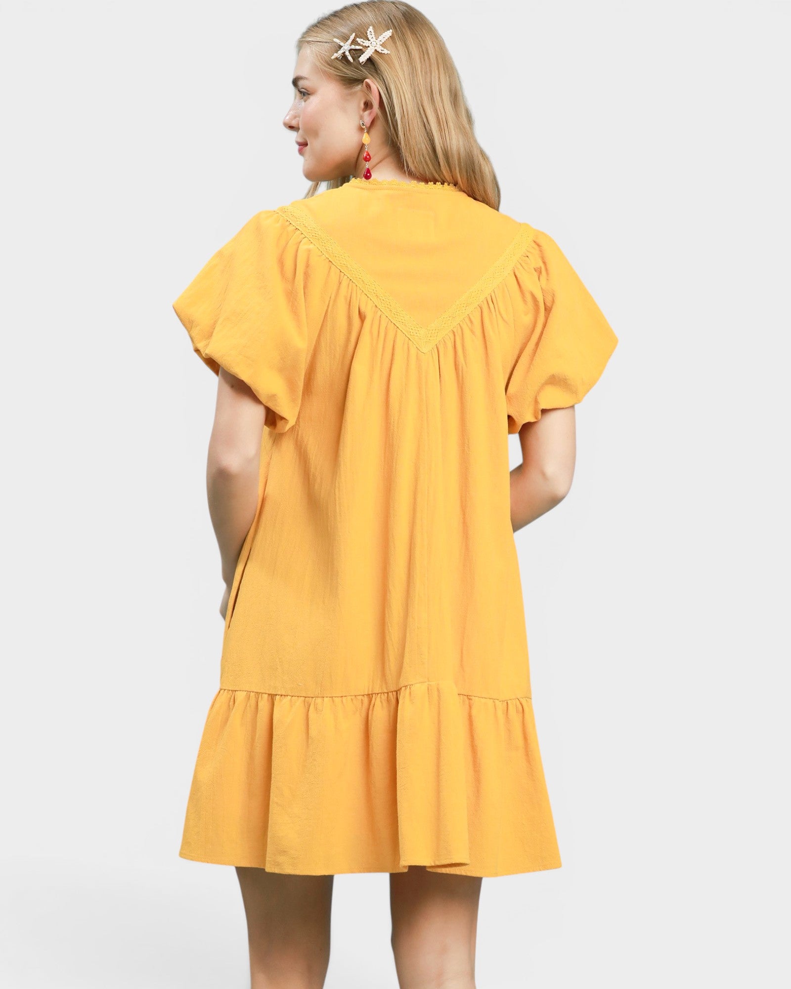 Woman wearing a yellow dress on a white background
