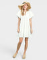 Woman wearing a white dress and straw hat on a plain background