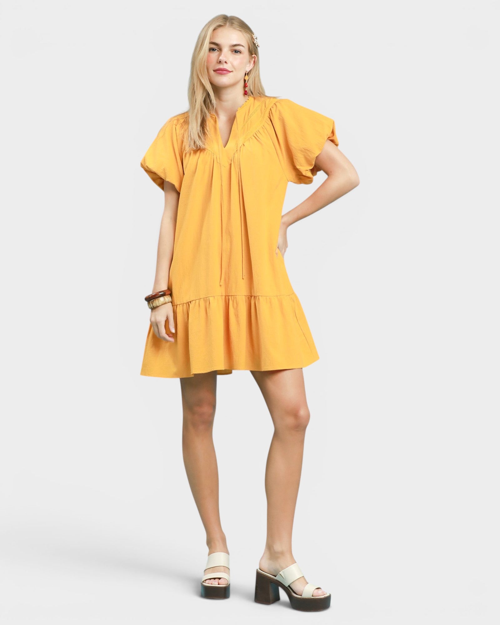 Woman wearing a yellow dress on a white background