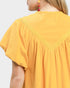 Yellow top with lace trim on a plain background