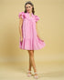 Woman wearing a pink dress against a beige background