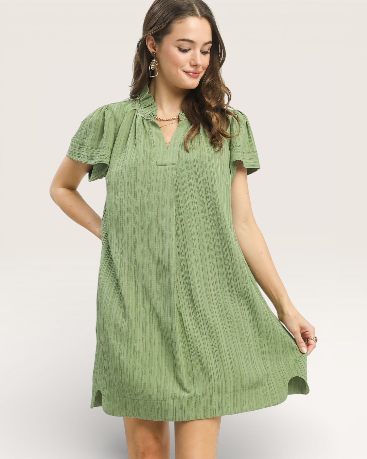 Woman wearing a green dress against a plain background