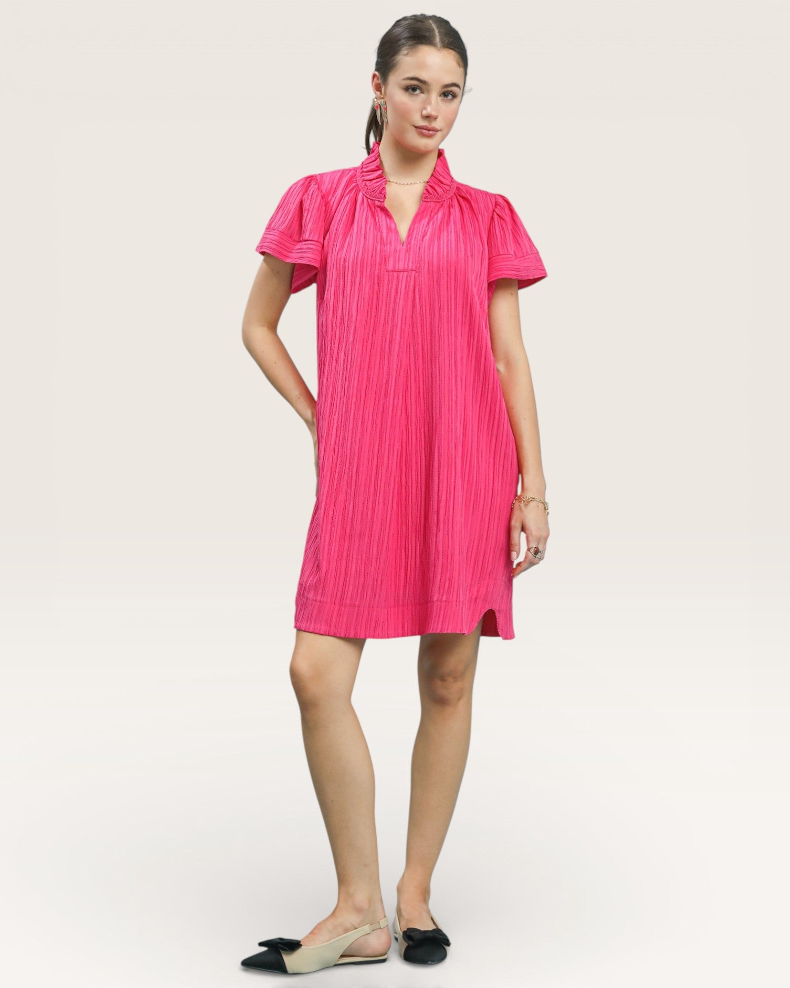 Woman wearing a bright pink dress on a white background