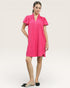 Woman wearing a bright pink dress on a white background