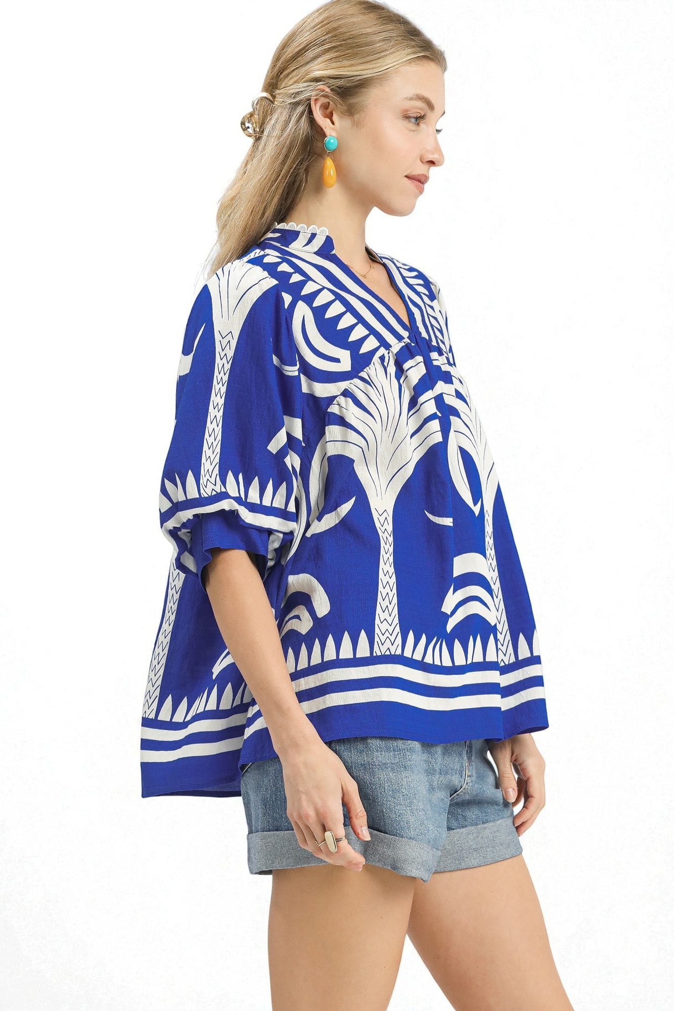 Woman wearing a blue and white patterned kimono-style top on a white background