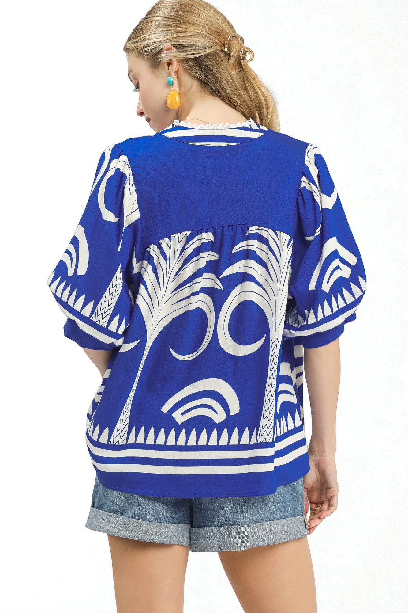 Woman wearing a blue and white patterned top on a white background